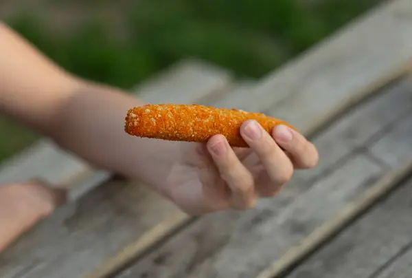 Kırsal ahşap masanın üzerinde kızarmış çıtır bir atıştırmalık tutuyor. Doğal gıda modeli markalaşma, paketleme veya yaşam tarzı gıda tasarımı için idealdir..