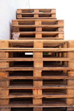 Uzun paletlerin yakın çekimi, simetrik endüstriyel bir perspektif yaratıyor, depo ve tedarik zincirinin sembolü.