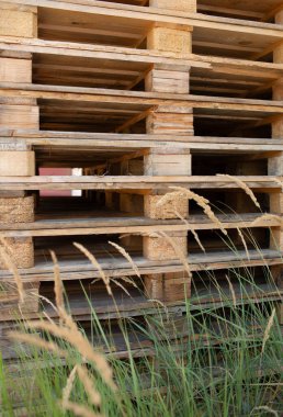 Duvarda duran uzun tahta paletler, endüstriyel lojistik konsepti için dikey fotoğraf..