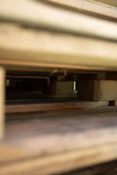 Paletlerin içindeki makro görüntü ahşap bloklar arasında ışık ve gölge gösteriyor.