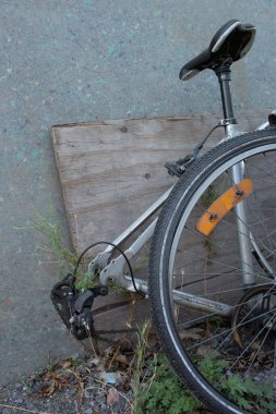 Duvara yaslanmış eski kırık bisiklet, terk edilmiş şehir taşımacılığının sembolü..