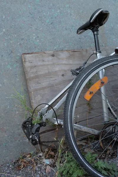 Duvara yaslanmış eski kırık bisiklet, terk edilmiş şehir taşımacılığının sembolü..