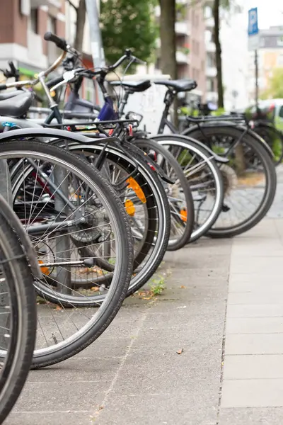 Bisiklet kuyruğu kentteki konut binalarının yakınındaki kaldırıma park edilmiş..