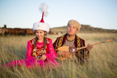 Kazakh woman and man in national costumes clipart