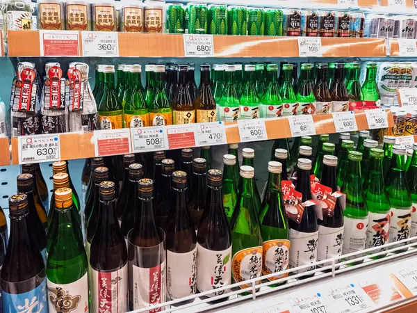 Nagoya, Japonya- 12 Nisan 2025: Soğuk içecekler üzerindeki sake şişeleri süpermarkette Japon Alkol içeceği rafı