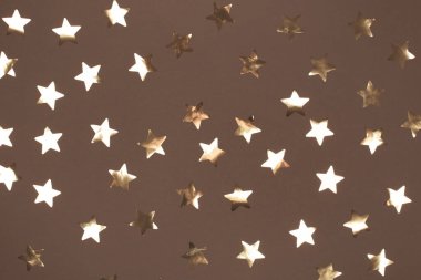 Bu görüntüde moka ve köpük arka planında altın yıldız şekilleri yer almaktadır, şenlik ve kutlama teması için mükemmeldir. 2025 yılının gösterim rengi.