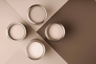 Kahverengi ve krem rengi geometrik arka planda dört adet açık boya kutusu düzenlenir. 2025 yılının gösterim rengi.