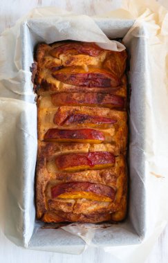 Ev yapımı vejetaryen şeftalili turta pişirme kalıbında. Mevsimlik meyveli yaz tatlısı, üst manzara.