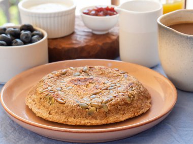 Kahvaltı için ev yapımı protein keto ekmeği dışarıda taze meyve, yoğurt, reçel ve kahve ile servis edilir. Protein tozu ve tohumlardan yapılmış mikrodalga fırında pişirilmiş ekmek ekmeği. Yakın çekim.