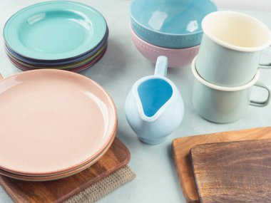 Şık ve zarif pastel renkli sofra takımı ve ahşap kesme tahtaları. Turkuaz arka planda yemek takımı