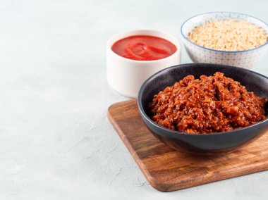 Gri arka planda soya proteini tanecikli domates bolonez ragu. Makarna için kolay vejetaryen soya sosu