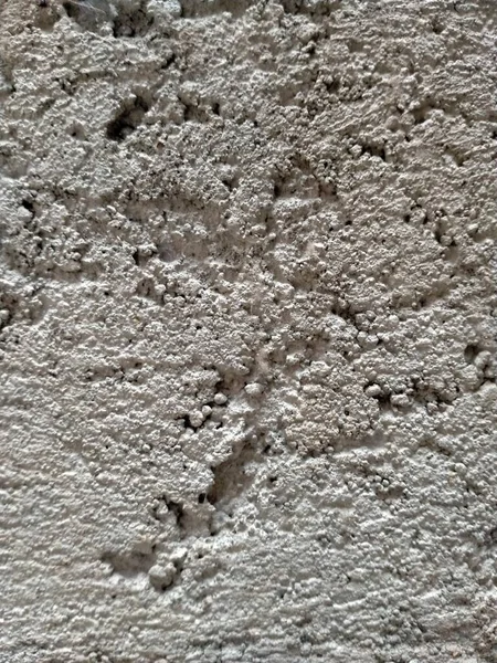 A wall plaster surface with a good cement content that has dried. Its texture characterises it.