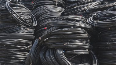Birçok siyah fiber optik kablo hattı büyük bir yığın halinde dizilmiş.