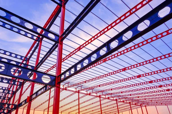 大型工业建筑在日落天空背景下的红 蓝金属系留梁结构低角度视图 — 图库照片