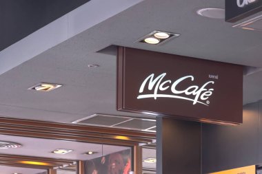 Chiang Mai, Tayland: 04 Aralık 2022: Modern McDonald 's restoranının içinde elektrikli tavan lambaları olan kahverengi Mccafe tabelalarının yan görünüşü