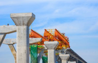 Metal launching gantry Structure for installing concrete typical Segment Joint on foundation of Flyover Expressway in road Construction site against cloudy on blue sky background
