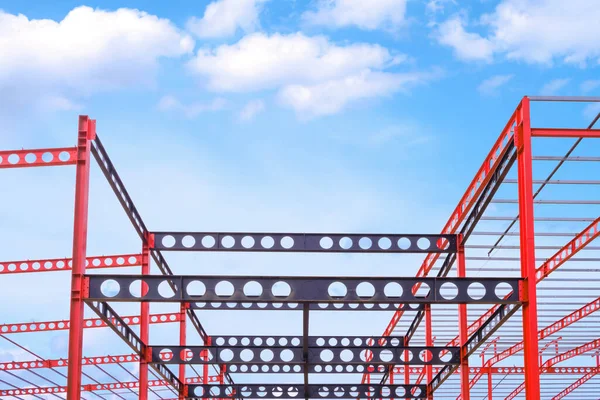 Red and black Castellated Beam metal of Industrial Building Structure in Construction Site against blue sky background
