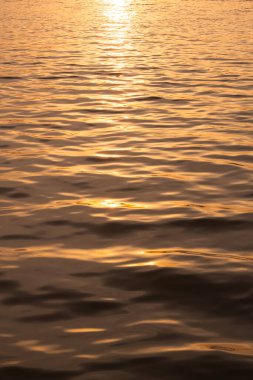 Beautiful golden sunlight reflection on river surface in morning sunrise time and vertical frame