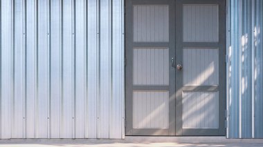 Background of the old wooden door on corrugated steel wall of storehouse with sunlight on surface