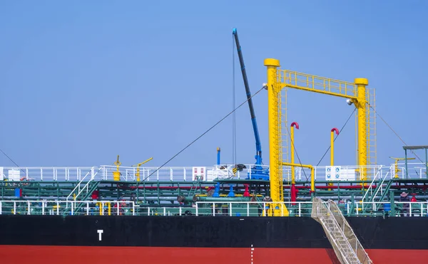 青い空を背景に港に係留中のタンカー船のクレーン機械と油パイプラインシステム — ストック写真