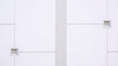 Modern beyaz ve gri beton çit duvarının arka planı 2 küçük kare biçiminde ve yüzeyde minimal şekilli geometrik çizgiler