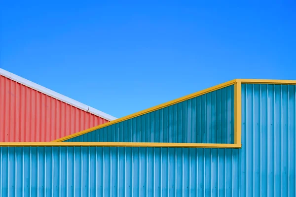 Two Colorful Corrugated Steel Warehouse Industrial Buildings against blue clear sky in Minimal style, Exterior Architecture Background Design concept