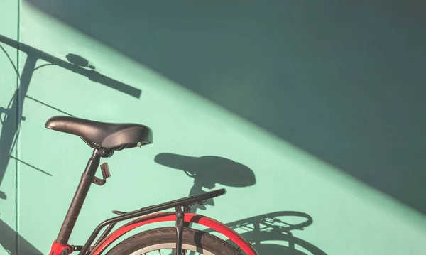 stock image Part of Folding Bicycle parking near green concrete wall with light and shadow on surface