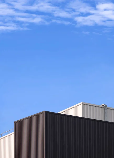 Moderne Schwarz Weiße Wellblech Fabrikgebäude Gegen Wolken Auf Blauem Himmelshintergrund — Stockfoto