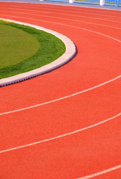 Vertical background of red synthetic Running Tracks and green field in Athletic Outdoors Stadium