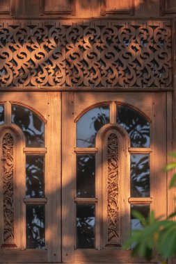 Dikey çerçevedeki eski klasik evin meşe ağacından yapılmış penceresinde ışık ve gölge.