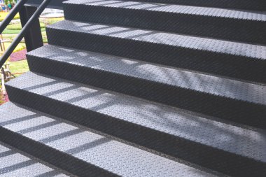 Güneş ışığı ve gölgesi doğanın siyah metal merdivenlerinde halka açık parkta yürüyüş, kopyalama alanı olan kenar görüş