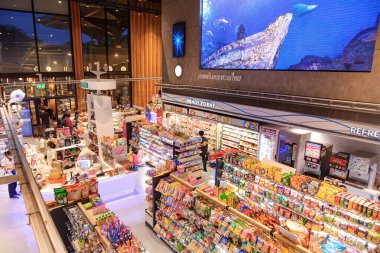 Pattaya, Chonburi, Tayland - Temmuz 09.2023: Müşteriler, Tara Pattaya 'nın akşamları modern tarzdaki okyanus temalı mağazasından alışveriş yapıyorlar