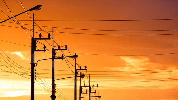 Silhouette Reihe Von Strommasten Mit Straßenlaternen Und Kabelleitungen Gegen Schönen — Stockfoto