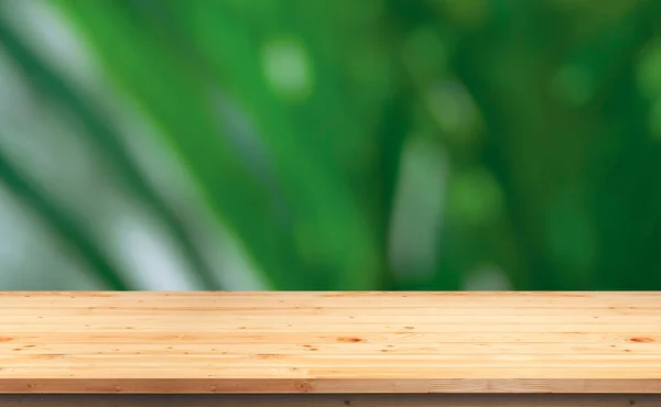 Empty wooden tabletop on blurred outdoor greenery background, suitable for product mockup display presentation
