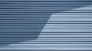 Güneş ışığı ve yüzeyinde gölgesi olan otomatik gri çelik kapaklı kepenk.