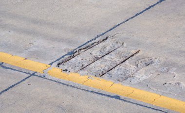 Yüzeyinde kırık ve çatlak dokusu olan eski hasarlı beton yol.