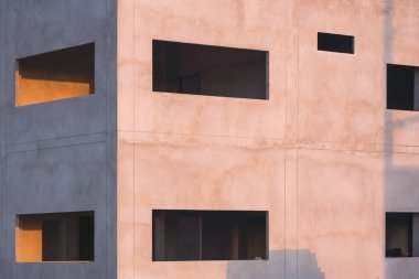 İnşaat alanındaki tamamlanmamış endüstriyel ofis yapısının beton duvarının yüzeyindeki güneş ışığı ve gölge.