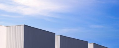 Modern siyah-beyaz kıvrımlı metal fabrika binaları mavi gökyüzü arka planı, panoramik ve perspektif yan görünümüne karşı