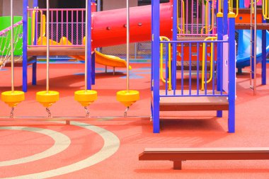 Çocuk dengesi kirişli renkli çocuk parkı ekipmanları anaokulundaki oyun parkında kauçuk zeminde.