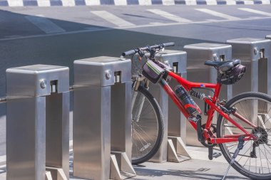 Otomatik otomatikman otomobil park makinelerinin arasına park etmiş bir bisiklet. Şehrin kaldırımında, güvensiz park konsepti.