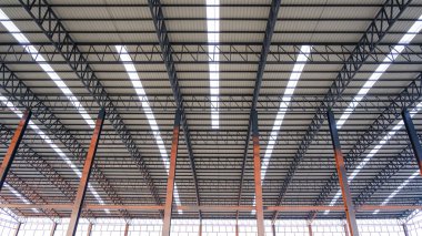Büyük endüstriyel fabrika binasının içinde alüminyum kıvrımlı çelik çatı kiriş yapısı, Geometrik mimari arka plan, düşük açı ve simetrik manzara