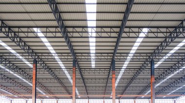 Büyük endüstriyel fabrika binasının içinde alüminyum kıvrımlı çelik çatı kiriş yapısı, Geometrik mimari arka plan, düşük açı ve simetrik manzara