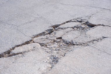 Eski ağır hasar görmüş beton sokak arka planı çökmüş ve yüzeyinde çatlak dokusu var.