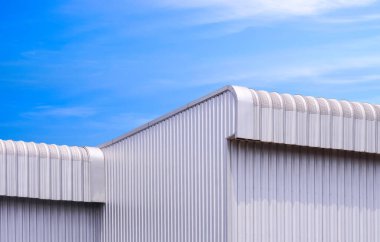 2 alüminyum çatılı Geometrik metal endüstriyel depo binası mavi gökyüzü arka planı, düşük açı ve kopya alanı ile perspektif yan görünümü 