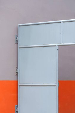 Dıştaki evin yanındaki dar sokağa gri metal giriş kapısı geometrik desenli minimal stil ve dikey çerçeve, ev mimarisi arka planı