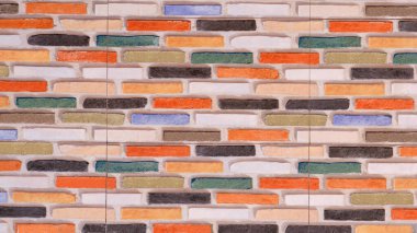 Tuğla desenli renkli fayans duvar dekorasyonu alçı dokusu ve eski tarz parlak suluboya tonuyla dekore edilmiştir.