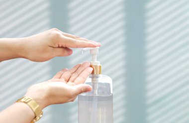 Beyaz duvar arkaplanındaki elleri temizlemek için pompa dezenfekte edici jel şişesi, fotokopi alanı ile kapatın.