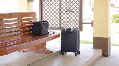 Tren peronunda eski ahşap bankta kamera çantasıyla bavul, perspektif kenar görünümü