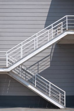Endüstriyel ofis duvarında yangın çıkışı. Yüzeyinde ışık, yüzeyinde gölge ve dikey çerçeve var.