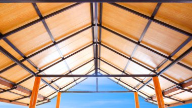 Tavan ahşap PVC plastik kompozit paneller. İnşaat, alçak açı ve simetri manzaralı vintage evin metal çatı kiriş yapısı.